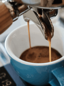 Espresso pouring into a blue coffee cup.
