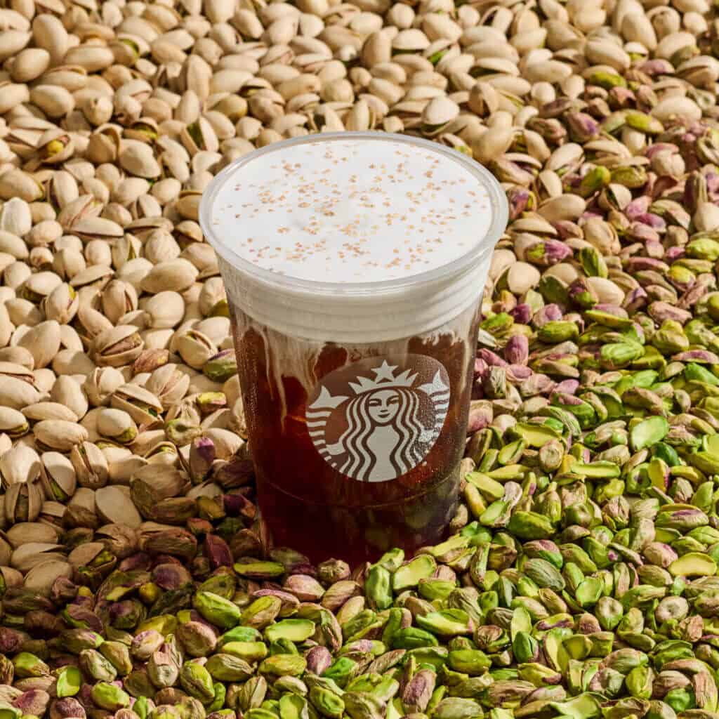Starbucks pistachio cold brew shown sitting in pistachios.