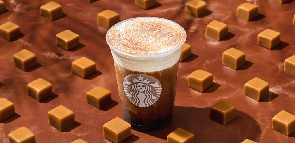 Starbucks Cinnamon Caramel Cold Brew on a chocolate brown table with caramels.