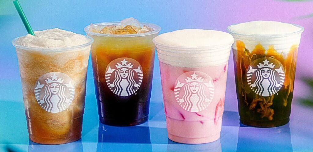Four Starbucks iced drinks on a blue table.