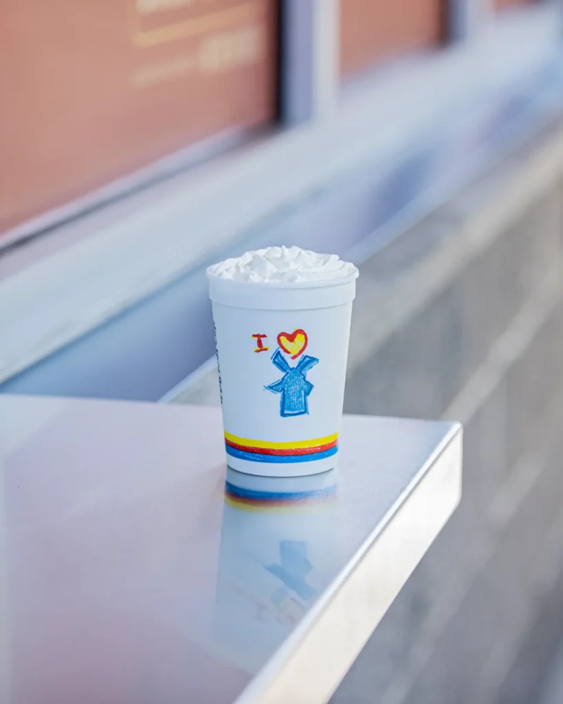 A Dutch Bros kids' cup sitting on a counter ledge.